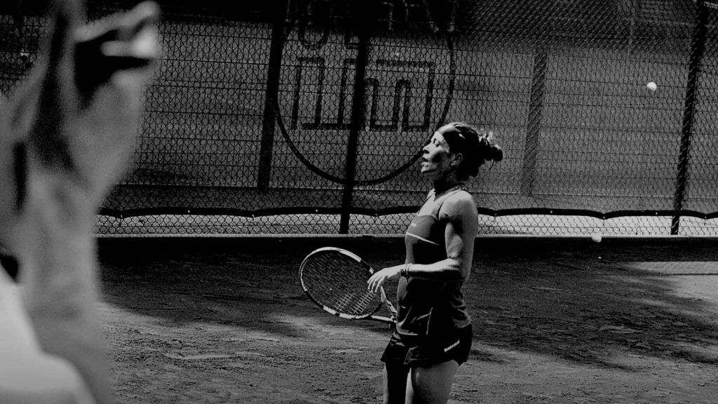 Bredeney 2017 - Following a long and energy-sapping rally the ball goes long. One can still see it flying in the upper right corner of the image. On the face of not too young anymore Lourdes Dominguez Lino, who is still terminating her last running effort, you can see the relief about this point win against a much younger player. She is gasping for breath. In the right foreground blur the applauding hands of an elderly person.